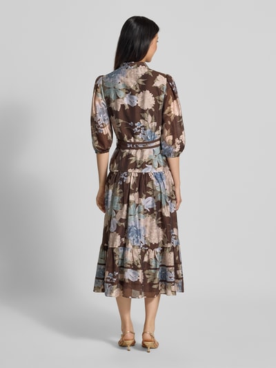 Vrouwenmodel draagt avondjurk van mix van lyocell en linnen, bloemenprint in bruine en blauwe tinten, Model 'Gianna' van Forever New, getailleerd, doorlopende knoopsluiting, 3/4-mouw met elastische zoom, laagjeslook, Maxilengte, ruglengte maat 36: 126 cm, borstwijdte maat 36: 45 cm, mouwlengte maat 36: 47 cm, volledige lichaamsweergave achteraan.
