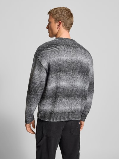 Männermodel trägt Oversized Strickpullover mit gerippten Abschlüssen von Pegador w odcieniach szarości, faktura dzianiny, Ganzkörperansicht Rückansicht.