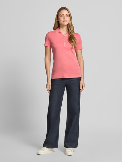 Frauenmodel trägt Regular Fit Poloshirt aus reiner Baumwolle von Tom Tailor, Optik: Unifarben, Kragenform: Polokragen, V-Ausschnitt, kurze Knopfleiste, Ärmelform: Kurzarm, Materialverarbeitung: Jersey, Ganzkörperansicht von vorne.