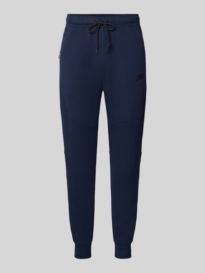 Produktfoto, dunkelblaue Slim Fit Sweathose aus Baumwoll-Mix von Nike, glatte Oberfläche, sichtbare Kordel, Herren Sweathose.