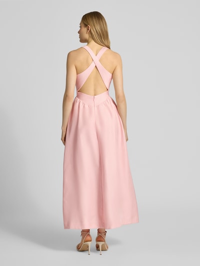 Frauenmodel trägt Cocktailkleid mit gekreuzten Trägern Modell 'Ottilie' von Forever New aus rosafarbenem Viskose-Leinen-Mix, A-Linie, Maxikleid, Rückenansicht.