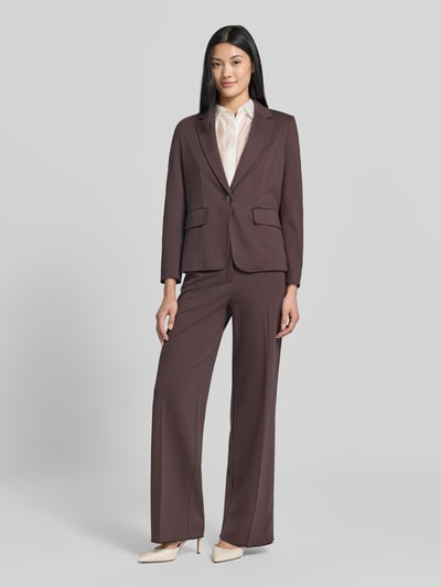 Frauenmodel trägt Blazer aus Viskose-Mix Modell 'Orche' von EMME in Braun mit Pattentaschen, taillierter Passform, Ganzkörperansicht von vorne.