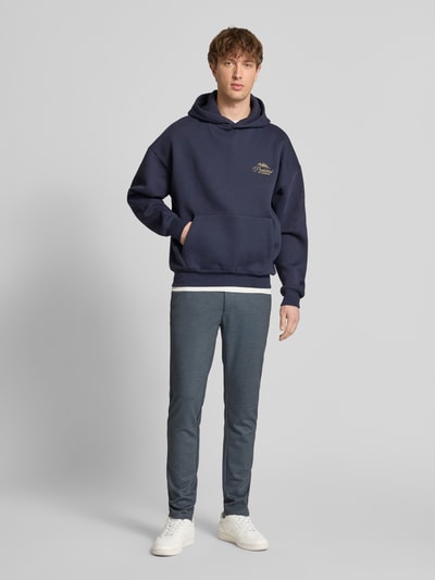 Männermodel trägt Slim Fit Chino aus Viskose-Mix Modell 'MARK' von Only & Sons, unifarben, Melange, Ganzkörperansicht von vorne.