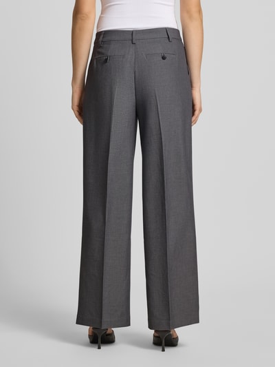 Frauenmodel trägt Wide Fit Stoffhose mit Viskose-Anteil von Gina Tricot, grau, Bügelfalten, Gesäßtaschen, Ganzkörperansicht Rückansicht.