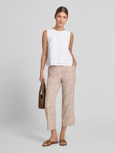 Frauenmodel trägt Hose aus Leinen-Baumwoll-Mix mit Stitchings von Christian Berg Woman, beige mit weißen Nähten, verkürzte Passform, Eingrifftaschen, Knopf- und Reißverschluss, kombiniert mit weißem Top und braunen Sandalen, Ganzkörperansicht von vorne.