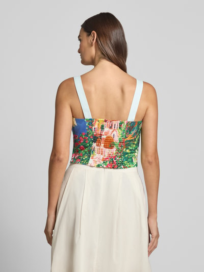 Frauenmodel trägt Cropped Blusentop mit Smok-Details von Stefanel in buntem Allover-Look aus Reine Baumwolle, Rückenlänge 21 cm, Ganzkörperansicht Rückansicht.