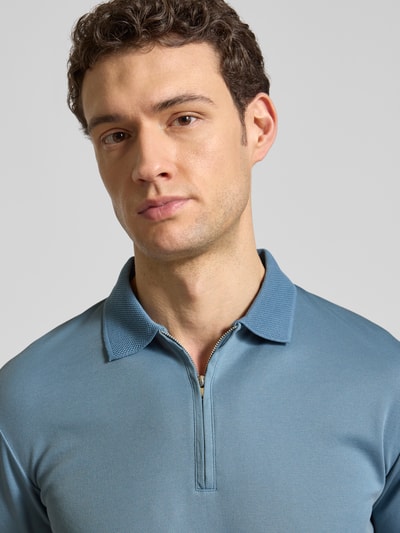 Männermodel trägt Regular Fit Poloshirt aus Bio-Baumwoll-Mix Modell 'FAVE' von SELECTED HOMME in Unifarbe, Nahaufnahme Oberkörper.