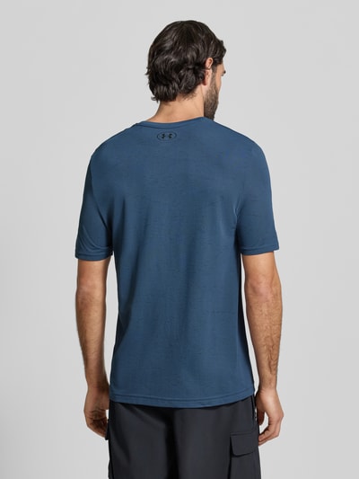 Mężczyzna nosi Slim Fit T-Shirt mit Logo-Print Modell 'Vanish' von Under Armour, kolor niebieski, okrągły dekolt, strukturalne dziurkowanie, szerokość w rozmiarze M: 40 cm, długość wewnętrzna nogawki w rozmiarze M: 70 cm, krój slim fit, widok całej sylwetki od tyłu