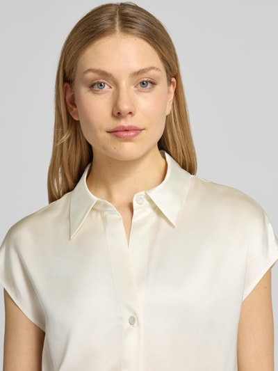 Modelka kobieca nosi Regular Fit Bluse aus Seide mit Knopfleiste od Luisa Cerano, czysta jedwab, kołnierzyk koszulowy, kolor kremowy, widoczna gładka tekstura, długość tyłu i rękawa w rozm. 36, ujęcie z przodu, zbliżenie na górną część ciała.