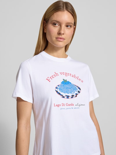 Modelka nosi Regular Fit T-Shirt mit Logo-Print von Lanius z bawełny, okrągły dekolt, nadruk z logo, długość tyłu 58 cm w rozmiarze 36, zbliżenie na górną część ciała.