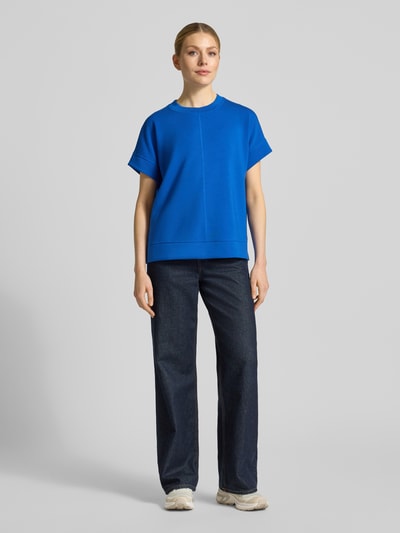 Vrouwenmodel draagt Relaxed Fit T-Shirt aus Modal-Mix van s.Oliver RED LABEL, effen blauw, scuba-textuur, ronde hals, korte mouw, zijslitten, volledige lichaamsvooraanzicht.