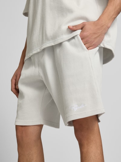 Männermodel trägt Shorts mit Logo-Stitching und elastischem Bund von Pegador aus Reine Baumwolle in Feinripp, Nahaufnahme Oberschenkel.