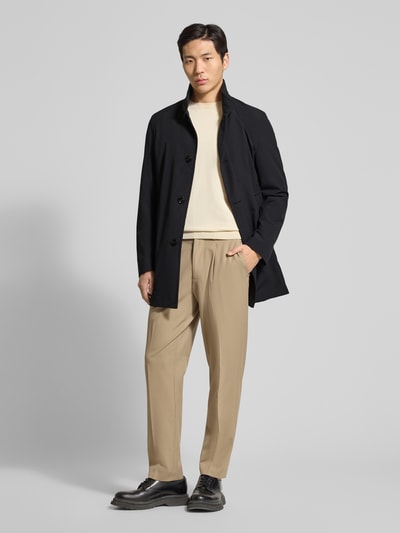 Męski model prezentuje Regular Fit krótki płaszcz z wyhaftowanym logo i naszywką, model 'FYNN' od Strellson, splot twill, efekt: jednolity kolor, stójka, listwa guzikowa, wpuszczane kieszenie i kieszeń napoleonka, długi rękaw, rozcięcie z tyłu; pełna sylwetka z przodu.