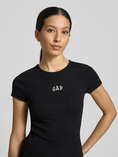 Frauenmodel trägt T-Shirt in Ripp-Optik mit Logo von GAP aus Baumwoll-Mix mit Modal-Anteil, Slim-Fit, Rundhalsausschnitt, Nahaufnahme Oberkörper.