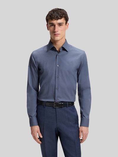 Männermodel trägt Slim Fit Businesshemd aus Baumwoll-Mix Modell 'H-HANK-KENT' von BOSS, Optik: Unifarben, Ganzkörperansicht von vorne.