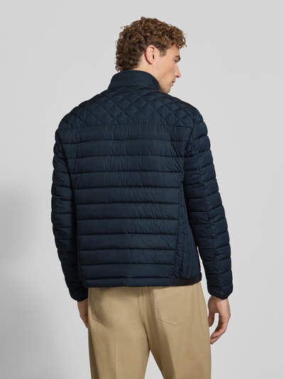 Männermodel trägt Steppjacke mit Stehkragen und Reißverschlusstaschen von Christian Berg Men in Dunkelblau, Rückenansicht, Regular Fit, KI-modifiziertes Bild.