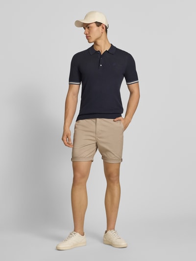Männermodel trägt Regular Fit Shorts mit Münztasche von Superdry, Beige, Baumwoll-Mix, Gesäßtaschen, Knopf-Reißverschluss, Ganzkörperansicht von vorne.