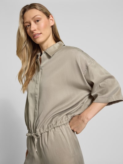 Kobiece modelka nosi Relaxed Fit Bluse aus Modal-Mix Modell 'Lainay' od Drykorn w beżowym kolorze, półrękaw, tunel w dole, kołnierzyk koszulowy, modal-mix, długość tyłu 55 cm, długość rękawa 27 cm, ujęcie z przodu, zbliżenie na górną część ciała.