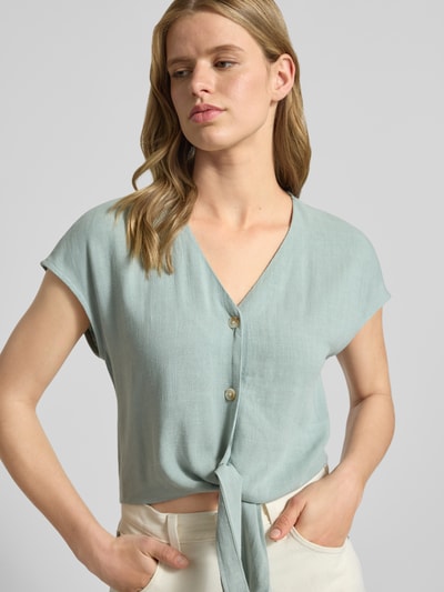 Frauenmodel trägt Regular Fit Blusentop aus Viskose-Leinen-Mix Modell 'SIESTA' von Only in Melange-Optik mit Knotendetail, Flammgarn-Textur, Nahaufnahme Oberkörper.