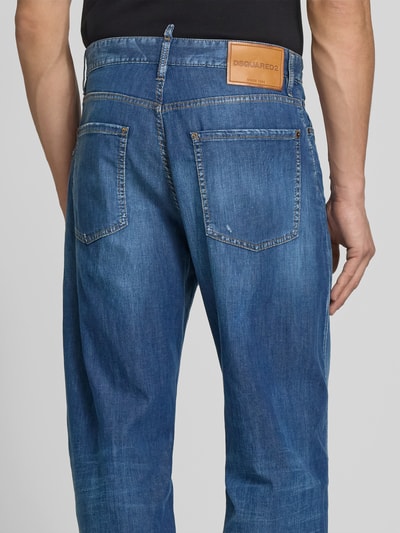 Männermodel trägt Loose Fit Jeans im Destroyed-Look von Dsquared2, blaue Denim-Optik, 5-Pocket-Design, Rückansicht, Nahaufnahme Oberkörper.