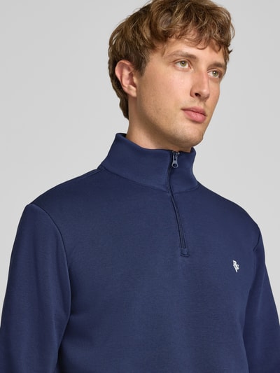 Mężczyzna nosi Sweatshirt aus reiner Baumwolle od REVIEW w kolorze granatowym, wyhaftowane logo, kołnierz zapinany, luźny krój, prążkowane wykończenia, długość tyłu 68 cm, długość rękawów 66 cm, komfortowa bawełna, półzbliżenie górnej części ciała.
