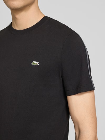 Männermodel trägt Regular Fit T-Shirt aus reiner Baumwolle von Lacoste, Optik: Unifarben, Applikation: Label-Tape, Nahaufnahme Oberkörper