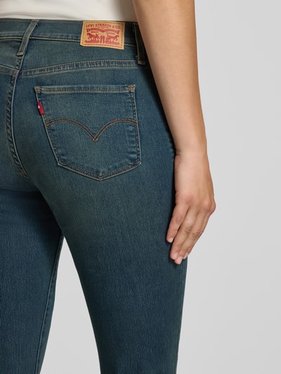 Frauenmodel trägt Straight Fit Jeans aus Baumwoll-Mix Modell '315®' von Levi's® 300, blaue Denim-Optik, sichtbare Nähte, Nahaufnahme Rückansicht.