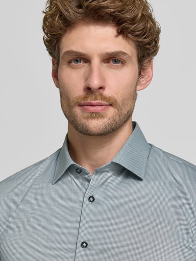 Männermodel trägt Super Slim Fit Businesshemd aus Baumwoll-Mix von OLYMP No. Six in Hellgrau mit feinem Muster, Nahaufnahme Oberkörper.