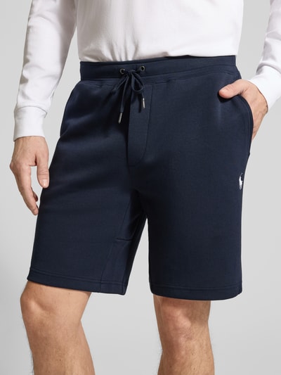 Männermodel trägt Regular Fit Sweatshorts aus Baumwoll-Mix von Polo Ralph Lauren in Dunkelblau, unifarben, Logo-Stitching, Nahaufnahme Oberkörper