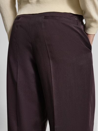 Männermodel trägt Wide Leg Bundfaltenhose aus Lyocell Modell 'C-PAT-BB-DPL-262' von BOSS, unifarben, glatte Textur, Nahaufnahme Rückansicht.