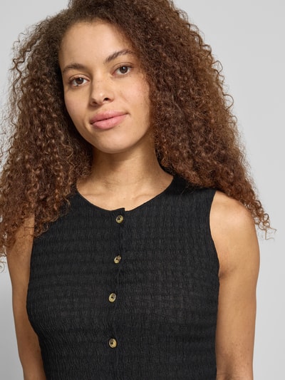 Frauenmodel trägt Slim Fit Weste mit Seersucker-Struktur Modell 'ILSE' von Only, unifarben, strukturierte Oberfläche, Nahaufnahme Oberkörper.