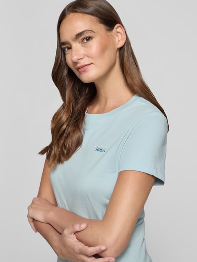 Vrouwenmodel draagt Regular Fit T-shirt uit zuivere katoen model 'C_ESOGO_1' van BOSS Orange; lichtblauw, glad oppervlak. Nahaufnahme bovenlichaam.