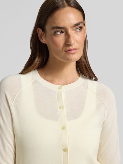 Frauenmodel trägt Relaxed-Fit Strickjacke aus reiner Schurwolle Modell 'FONAMI' von BOSS, cremefarben, feine Strickstruktur, Nahaufnahme Oberkörper, Damen Strickjacke.