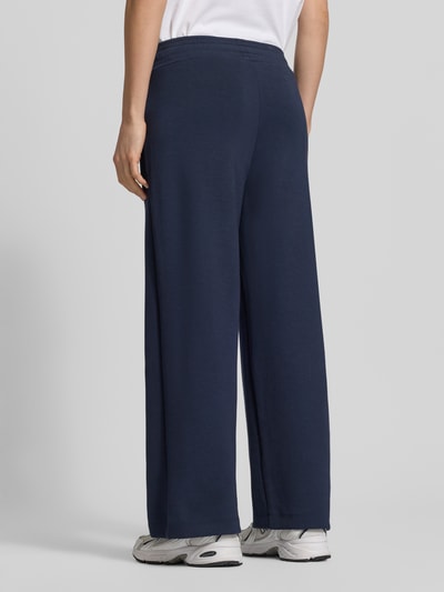 Vrouwenmodel draagt donkerblauwe Sweatpants met elastische band Model 'Banu' van Soyaconcept, materiaalmix met modal, los model, steekzakken, tunnelkoord. Volledig aanzicht achterkant.