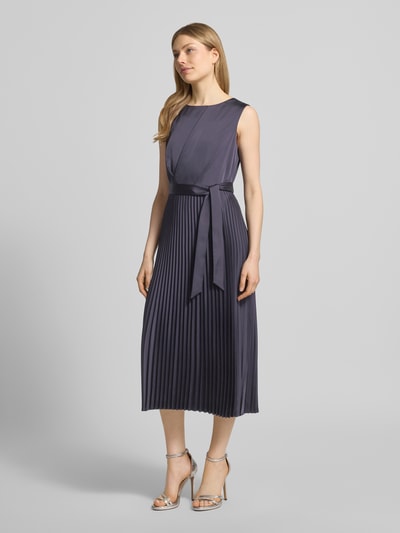 Frauenmodel trägt Midikleid mit Plisseefalten und Bindegürtel von Comma, Material-Mix mit Stretch-Anteil, A-Linie, Ganzkörperansicht von vorne.