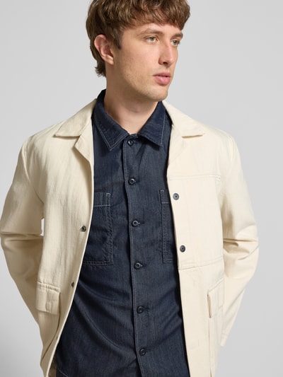 Männermodel trägt Regular Fit Freizeithemd aus Lyocell-Mix Modell 'Bowling' von G-Star Raw in Denim-Optik mit Brust-Taschen, Reverskragen und durchgängiger Knopfleiste, Rückenlänge 72 cm, Schulterbreite 48 cm, Ärmellänge 30 cm, Ganzkörperansicht von vorne.