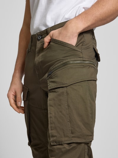 Mężczyznamodel nosi Regular Tapered Fit Cargohose mit Reißverschlusstasche od G-Star RAW, bawełniano-elastanowy materiał, zbliżenie na biodra.