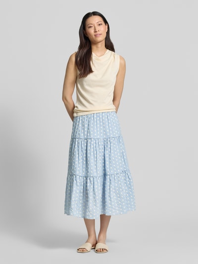 Frauenmodel trägt Midirock im Stufen-Look Modell 'Morning' von LOLLYS LAUNDRY aus reiner Baumwolle, A-Linie, hellblau mit weißen Punkten, Ganzkörperansicht von vorne. Bundweite bei Größe S: 37 cm, Gesamtlänge bei Größe S: 79 cm.