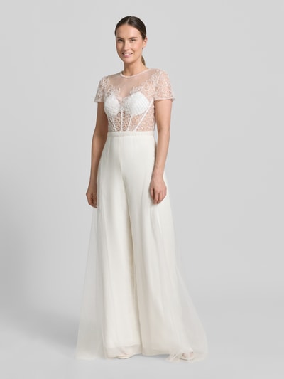 Frauenmodel trägt Jumpsuit mit Perlen und rückseitigem Cut-Out von Unique, Semitransparent, Regular-Fit, Cremefarben, Ganzkörperansicht von vorne. Rückenlänge 40 cm, Brustweite 38 cm, Ärmellänge 17 cm, Gesamtlänge 162 cm, Innenbeinlänge 86 cm, Hakenverschluss.