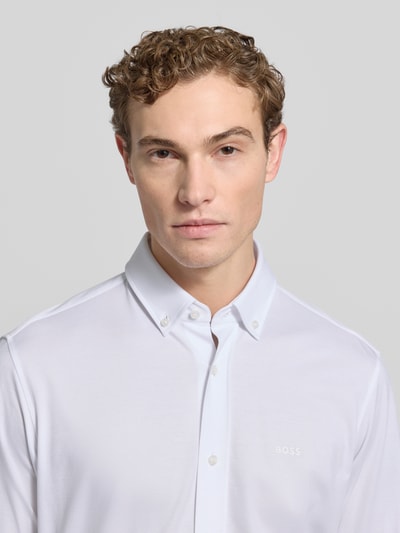 Männermodel trägt Regular Fit Businesshemd aus Pinpoint mit Stretch-Anteil von BOSS, Baumwoll-Mix, Logo-Schriftzug, Nahaufnahme Oberkörper.
