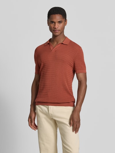 Męski model nosi Slim Fit Poloshirt mit V-Ausschnitt Modell 'Braian' von Drykorn, bawełna, strukturalny wzór, przód, ujęcie całopostaciowe.