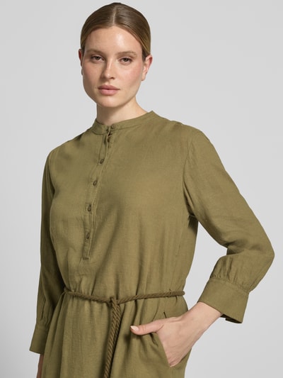 Frauenmodel trägt Midikleid aus Leinen-Mix mit Bindegürtel von Fynch-Hatton in Oliv, Leinen-Viskose-Anteil, taillierter Schnitt, Mao-Kragen, Knopfleiste, Bindegürtel in Kordel-Optik, abgerundeter Saum, Rückenlänge bei Größe 36: 112 cm, Brustweite: 52 cm, Ärmellänge: 52 cm, Nahaufnahme Oberkörper.