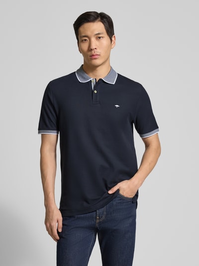 Männermodel trägt Modern Fit Poloshirt mit Stitching von Fynch-Hatton, bawełna, krój modern fit, granatowy, polokrót, guzik, całkowity widok z przodu.