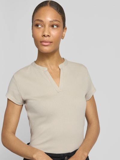 Frauenmodel trägt T-Shirt in Ripp-Optik Modell 'Kleoh' von Someday in Beige, V-Ausschnitt, Slim Fit, Nahaufnahme Oberkörper.