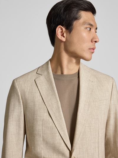 Männermodel trägt Slim Fit Anzug mit Viskose-Anteil Modell 'CIDATI' von CINQUE in Beige, melierte Textur, Nahaufnahme Oberkörper.