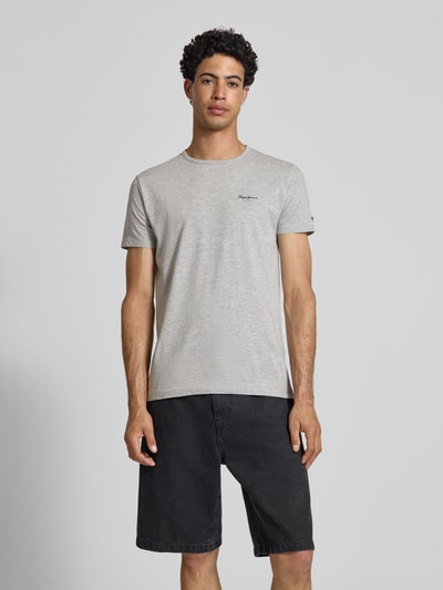 Männermodel trägt Slim Fit T-Shirt aus Baumwoll-Mix Modell 'ORIGINAL BASIC 3' von Pepe Jeans in Melange-Optik, Unifarben, Label-Schriftzug, Rundhals, Kurzarm, Jersey, Ganzkörperansicht von vorne.