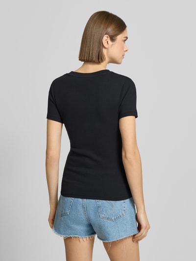 Kobiece modelka nosi czarne T-shirt z label-patchem model 'Cavia' od Levi's®, bawełna, prosty krój, widok całej sylwetki z tyłu.