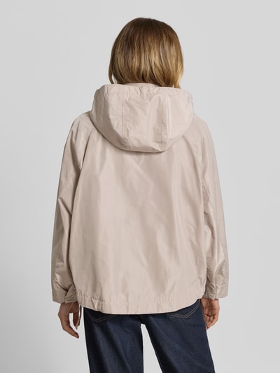 Kobiece model prezentuje jasnobeżową Jacke mit Kapuze Modell 'CICATA' od CINQUE, prosty krój, kaptur ze sznurkiem, stójka, zamek i zatrzaski, boczne kieszenie na zamek, dół ze sznurkiem, długość tyłu 60 cm, szerokość ramion 39 cm, szerokość w rozmiarze 36: 12 cm, długość rękawa 62 cm, gładka powierzchnia, widok całej sylwetki od tyłu