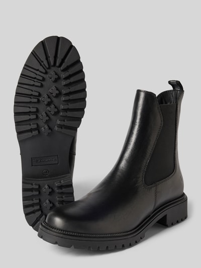 Produktfoto, schwarze Chelseas aus echtem Rindsleder von Tamaris für Damen, glänzende glatte Oberfläche, grobe Sohle, neutrale Studioaufnahme.