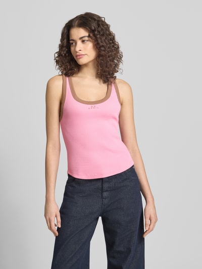 Frauenmodel trägt Slim Fit Top mit Logo-Stitching Modell 'Fiora' von OH APRIL in Rosa-Braun, Strukturmuster, Nahaufnahme Oberkörper. Elastischer Baumwoll-Mix, Rundhalsausschnitt, Rückenlänge 52 cm bei Größe S.